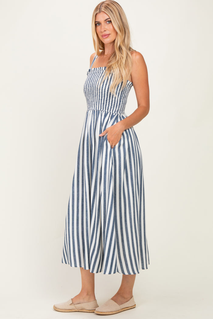 woman wearing a navy and white striped midi dress with a smocked bodice and pockets