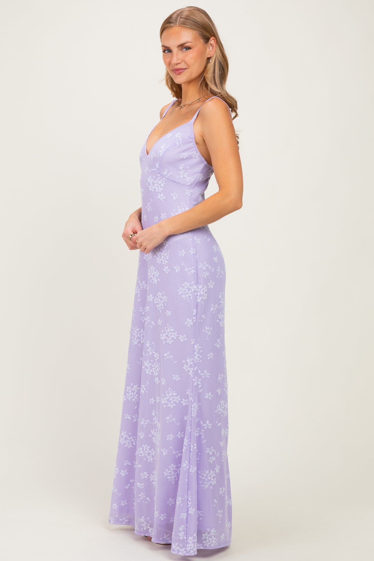 woman wearing a lavender floral maxi dress with spaghetti straps and a fitted bodice
