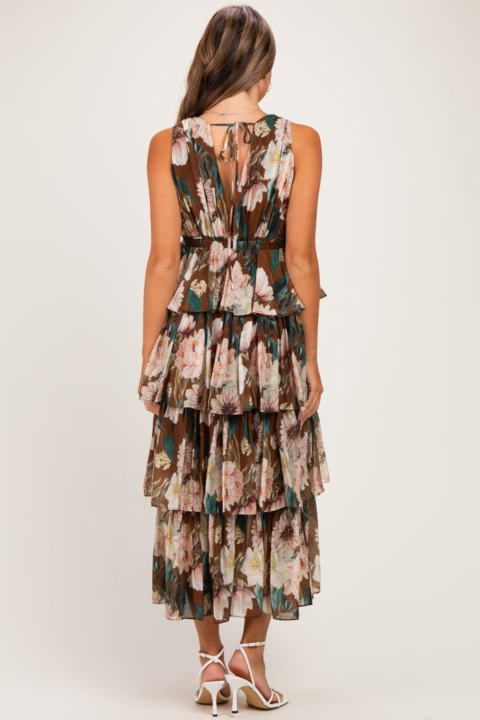 woman wearing a brown floral maternity maxi dress with a tiered design and open back details