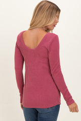 woman wearing a maroon ribbed long sleeve top with a scoop back and fitted style