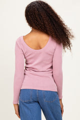 woman wearing a pink ribbed long sleeve top with a scoop back and styled with high-waisted jeans