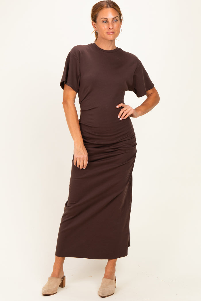 woman wearing a dark brown short sleeve maxi dress with gathered detail and a relaxed fit