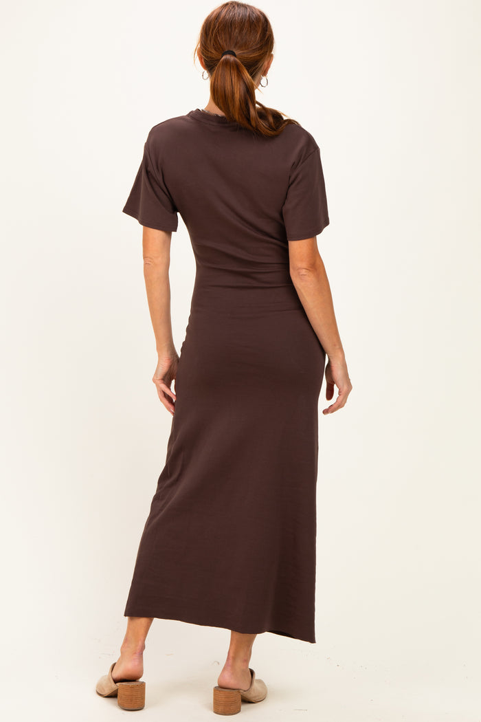 woman wearing a brown short sleeve maxi dress, standing with her back to the camera