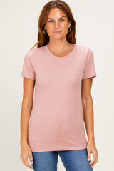 woman wearing a light pink short sleeve t-shirt with a round neckline and fitted style