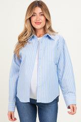 woman wearing a light blue striped maternity button-up shirt and showcasing her baby bump