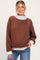 woman wearing a brown maternity sweatshirt with a light gray collar and cuffs, styled casually with jeans