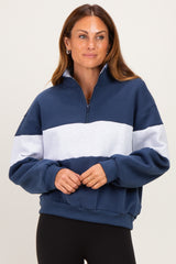 woman wearing a navy and grey color block quarter-zip sweatshirt with a relaxed fit and long sleeves