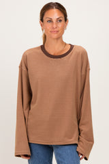 woman wearing a brown striped long sleeve top with a contrasting dark brown neckline and relaxed fit