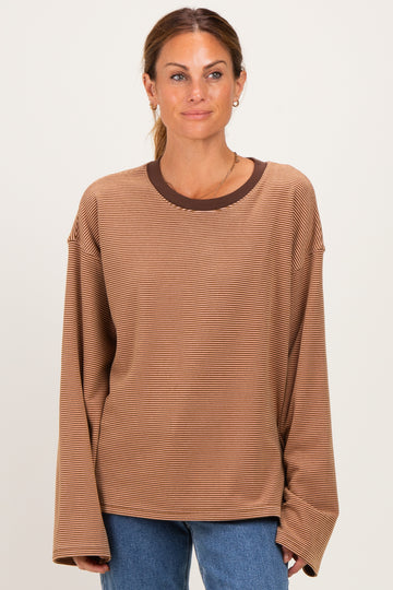woman wearing a brown striped long sleeve top with a contrasting dark brown neckline and relaxed fit