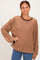 woman wearing a brown and tan striped long sleeve oversized top with a round neckline and relaxed fit