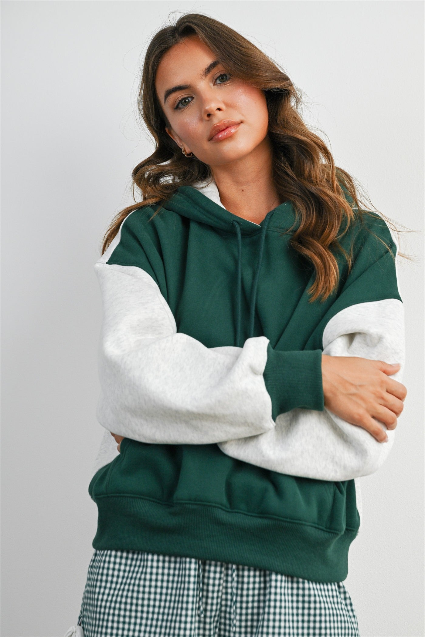 woman wearing a green and gray colorblock hoodie with a relaxed fit and drawstring hood