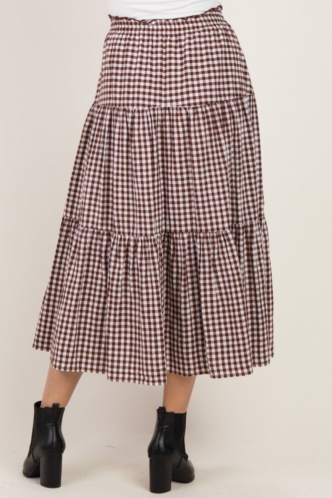 woman wearing a brown and white gingham tiered midi skirt with an elastic waistband and ankle boots