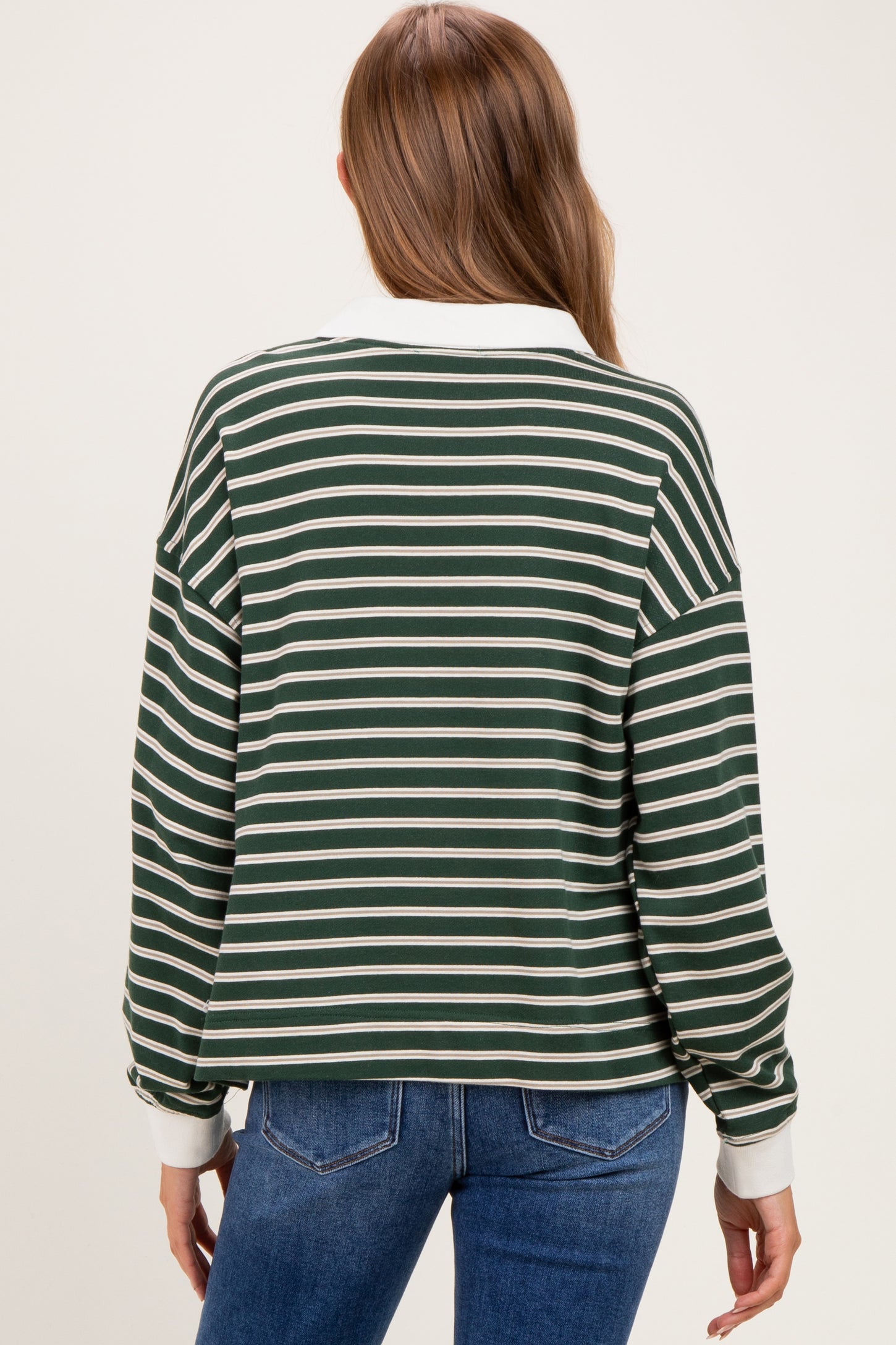 woman wearing a green and white striped maternity sweatshirt with a collared neckline and long sleeves, viewed from the back