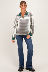 woman wearing a striped maternity sweatshirt with a green collar and sleeves, paired with flared jeans