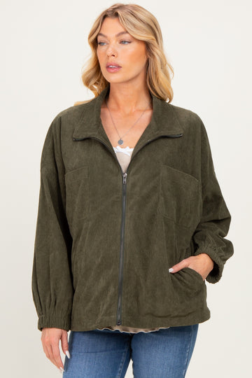 woman wearing a dark green maternity corduroy jacket with a zip front and two front pockets