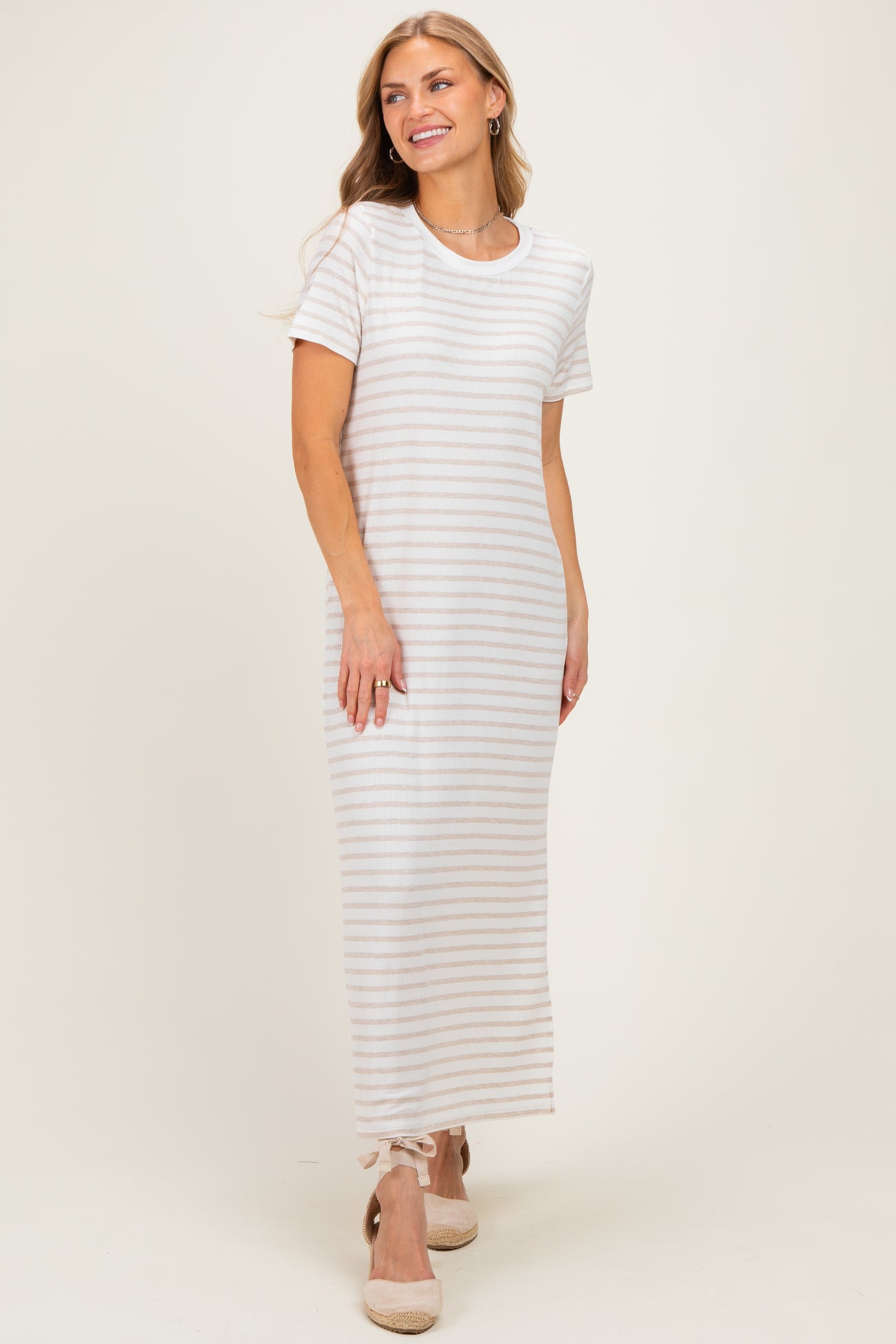 woman wearing a white and beige striped short sleeve maxi dress with a relaxed fit