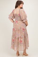 woman wearing a pastel floral maternity plus maxi dress with puff sleeves and ruffle details, showing a baby bump
