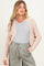 woman wearing a light pink cable knit cardigan over a gray t-shirt and loose gray pants, maternity wear