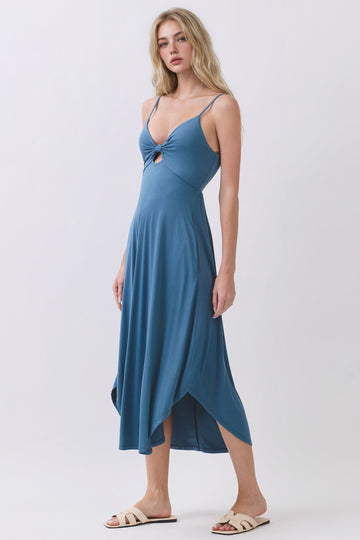 woman wearing a blue spaghetti strap midi dress with a front knot detail and an asymmetrical hemline