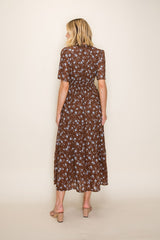 woman wearing a brown floral midi dress with short sleeves and a tiered skirt, shown from the back