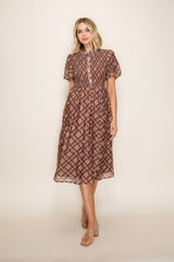 woman wearing a brown plaid midi dress with short puff sleeves and button details