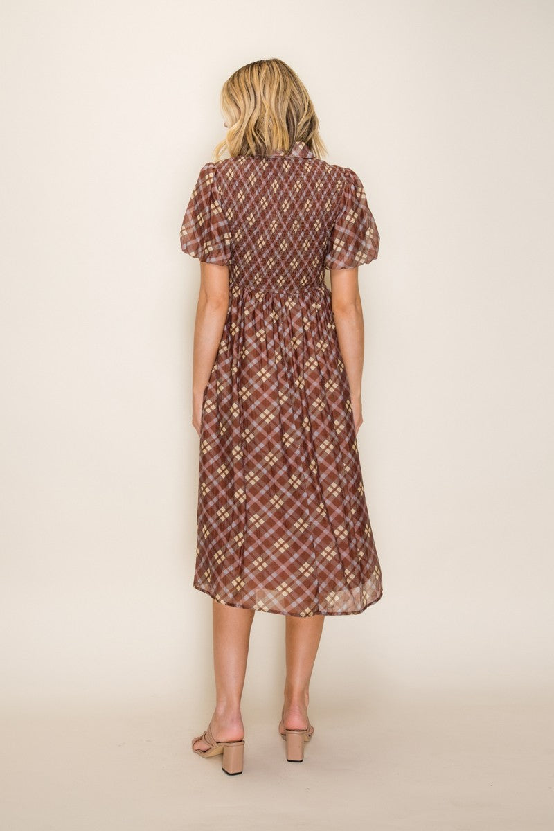 woman wearing a brown plaid midi dress with puff sleeves, showing the back view