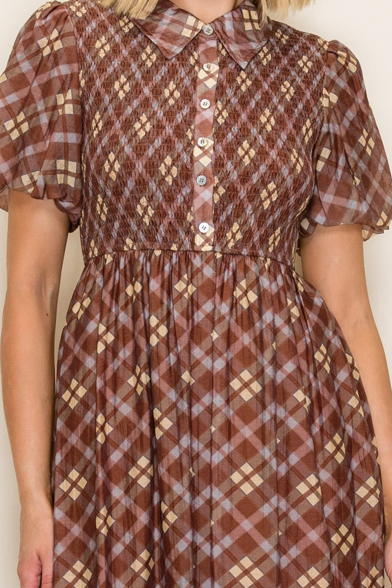 woman wearing a brown checkered midi dress with short puff sleeves and a button-down front
