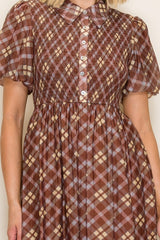 woman wearing a brown checkered midi dress with short puff sleeves and a button-down front