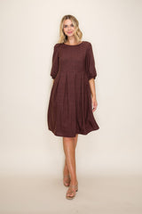 woman wearing a burgundy textured dress with three-quarter sleeves and a flared skirt