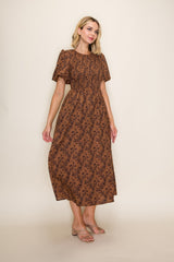 woman wearing a brown floral maxi dress with short sleeves and a gathered waist