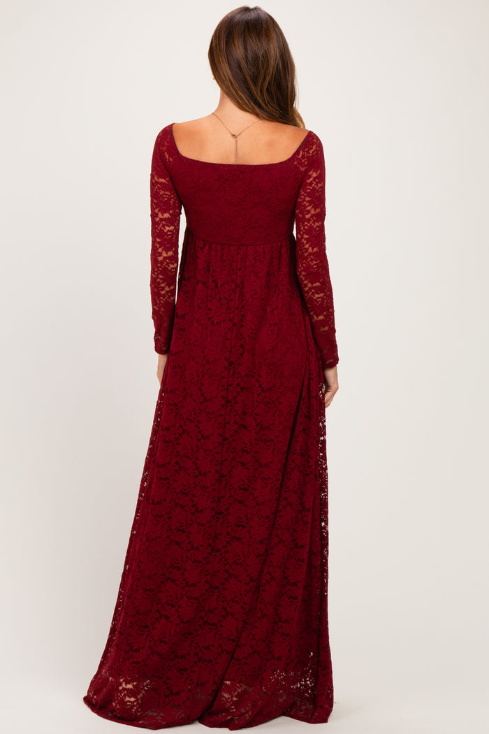woman wearing a burgundy long sleeve lace maxi dress, showing the back view with a fitted bodice and flowing skirt