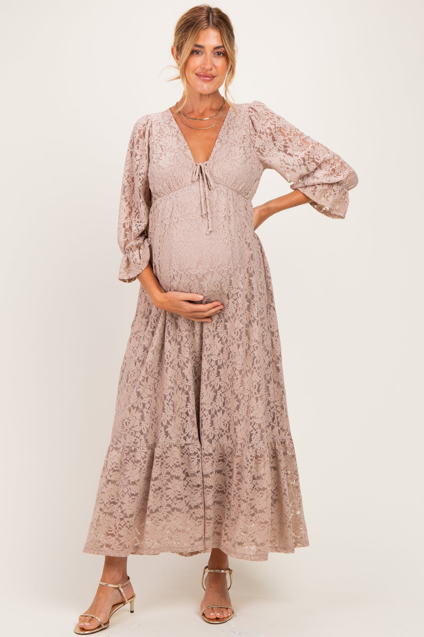 woman wearing a mauve lace maternity maxi dress with bell sleeves and a baby bump visible