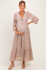 woman wearing a mauve lace maternity maxi dress with bell sleeves and a baby bump visible