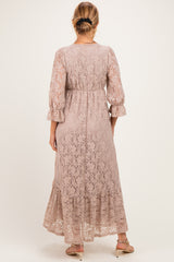 woman wearing a blush lace maternity dress with 3/4 sleeves and a flowy hem, showing a baby bump from the back