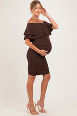 woman wearing a brown off-shoulder maternity dress with ruffle details and holding her baby bump