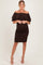 woman wearing a brown off-the-shoulder maternity dress with ruffles and a visible baby bump