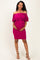 woman wearing a fuchsia off-shoulder maternity dress with ruffle details and showcasing her baby bump