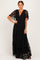 woman wearing a black lace maxi dress with flutter sleeves and a deep v-neckline