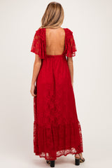 woman wearing a red lace maxi maternity dress with a low back and flutter sleeves