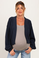 woman wearing a navy maternity cardigan over a gray top and showing her baby bump
