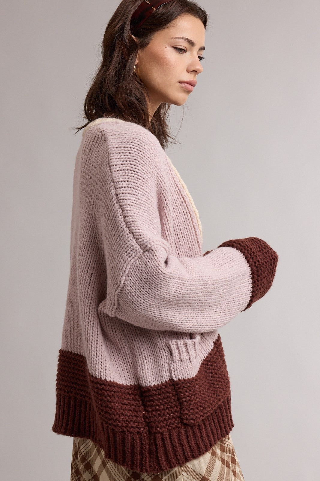 woman wearing a light pink and brown color-block oversized knit cardigan