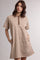woman wearing a brown and cream striped polo dress with short sleeves and pockets