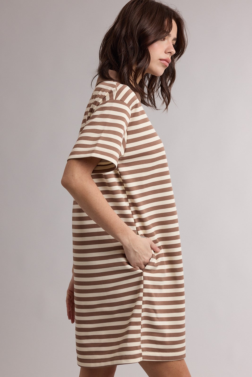 woman wearing a brown and beige striped short sleeve oversized dress with side pockets