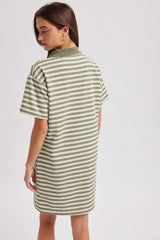 woman wearing a striped olive green oversized polo dress, showing the back view