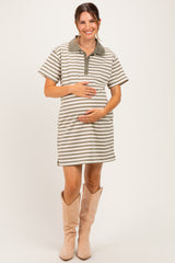 woman wearing a striped maternity polo dress in beige and green, smiling and holding her baby bump