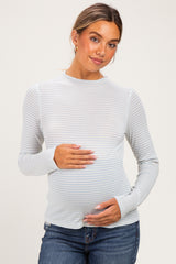 woman wearing a light blue and white striped maternity top with a baby bump visible