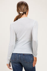 woman wearing a light blue long sleeve maternity top with subtle stripes, viewed from the back
