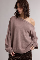 woman wearing a blush oversized off-the-shoulder sweater with wide sleeves and ribbed hem