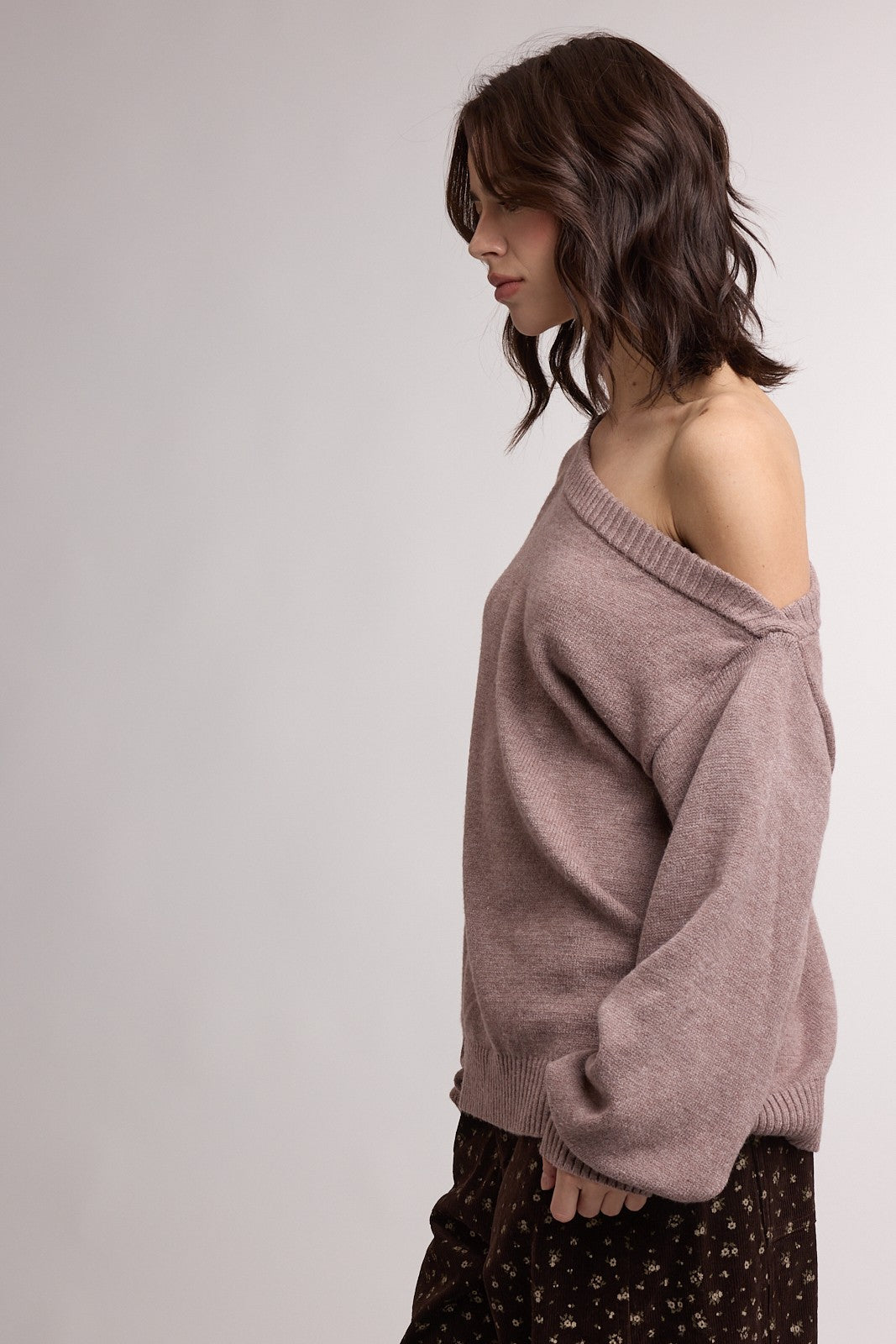 woman wearing a dusty rose off-the-shoulder oversized sweater with a relaxed fit and ribbed neckline