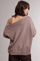 woman wearing a cozy mauve oversized sweater with an off-shoulder design and ribbed hem, seen from the back